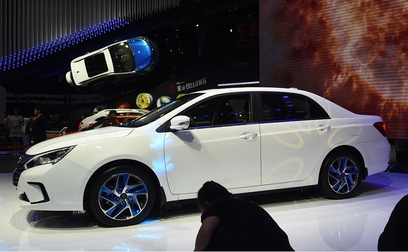 Staff clean near a BYD Qin 100 hybrid car at the Beijing Auto Show in Beijing on April 26, 2016. The show is the premier annual event for carmakers to present their latest models in China, the worlds biggest auto market. / AFP / GREG BAKER (Photo credit should read GREG BAKER/AFP/Getty Images)