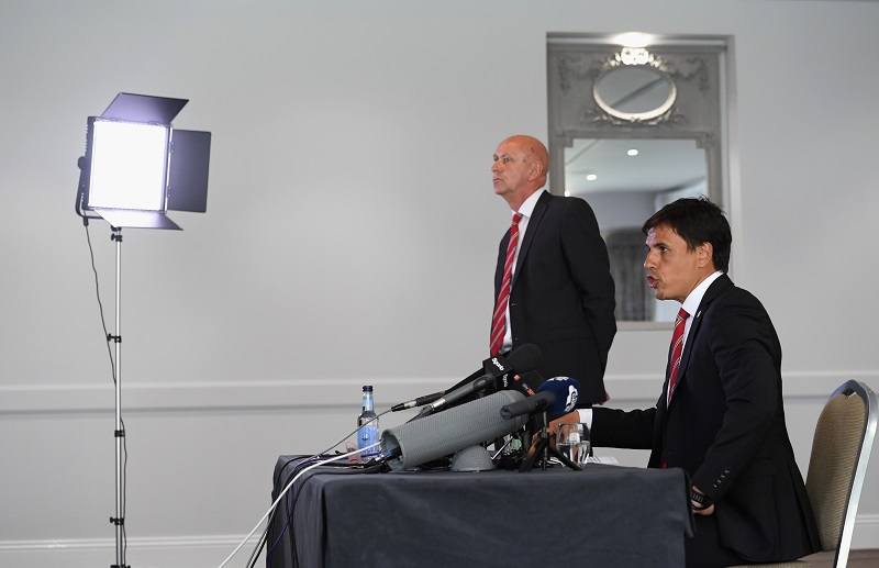 Wales soccer manager Chris Coleman speaks to the media under the watch of his communications manager
