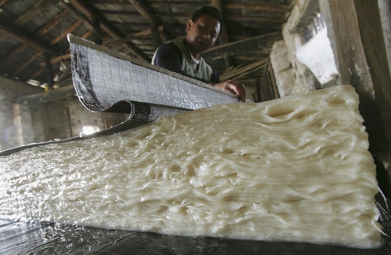 A Chinese worker producing paper from pulp
