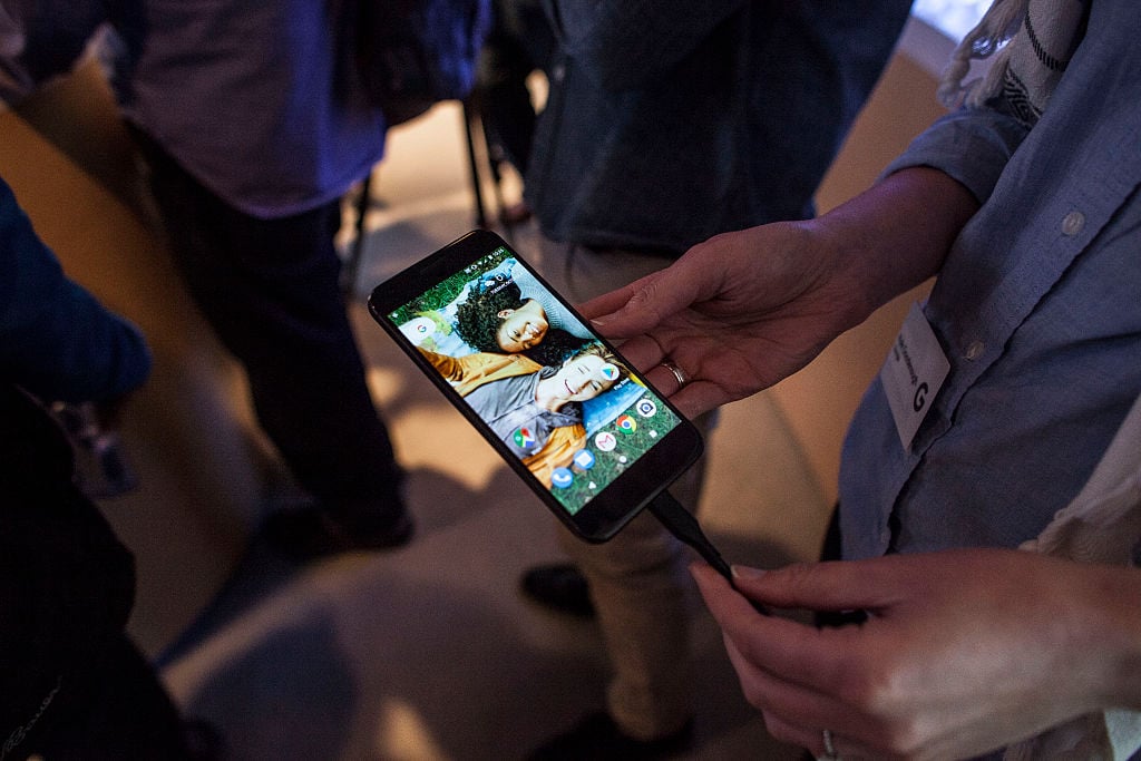 Members of the media examine Google's Pixel phone during an event