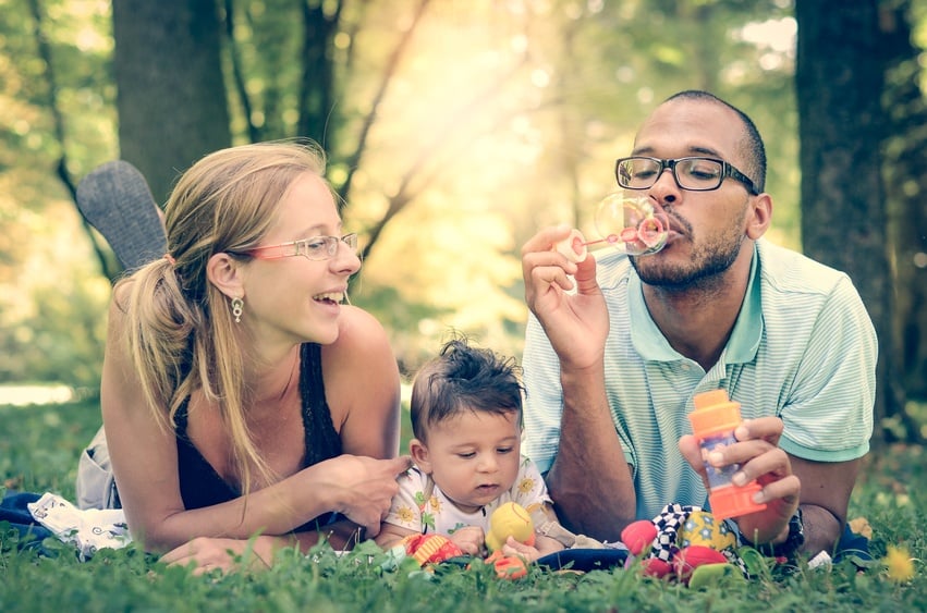 Happy interracial family is blowing bubbles