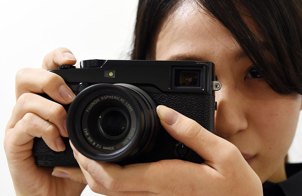 A Fujifilm employee poses with the company's new X-Pro2 premium mirrorless digital camera