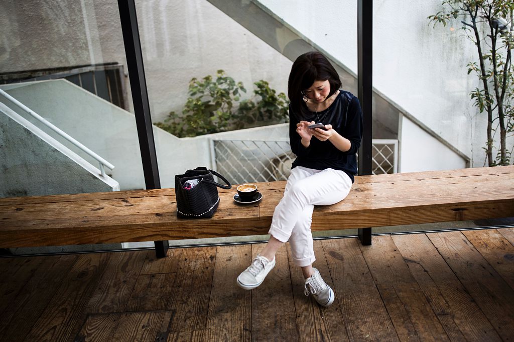 a Japanese woman checks her smartphone
