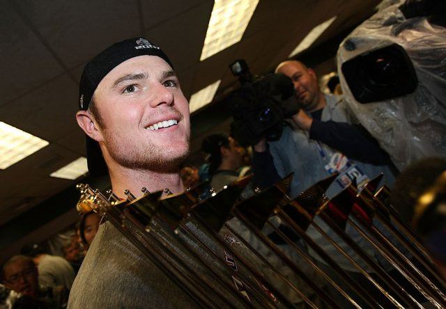 Starting pitcher Jon Lester of the Boston Red Sox celebrates with the trophy in the locker room