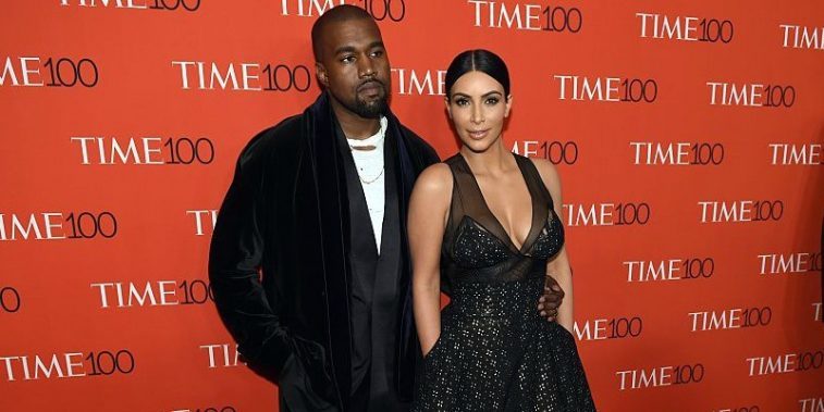 Kim Kardashian and Kanye West pose on the red carpet.