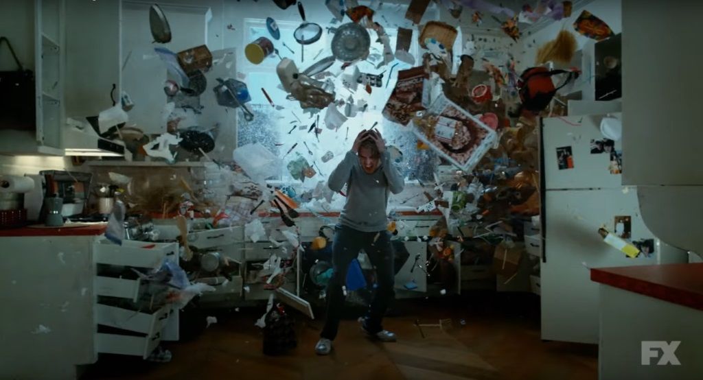 Dan Stevens cowers as objects fly around him in a scene from FX's Legion