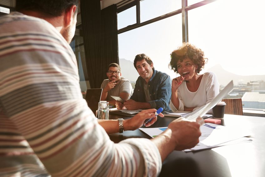 Shot of mixed race young people sitting at a table
