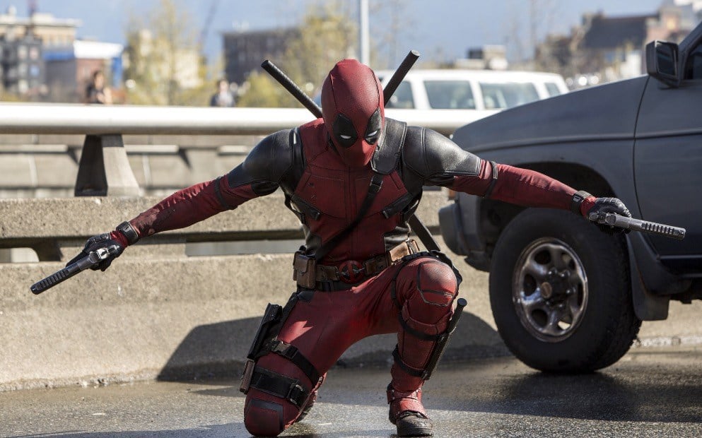Deadpool holding two guns while down on one knee