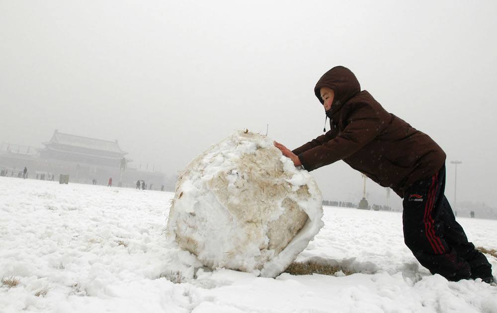 boy rolling a snowball