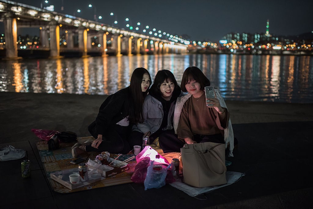 A group of women look at a mobile phone