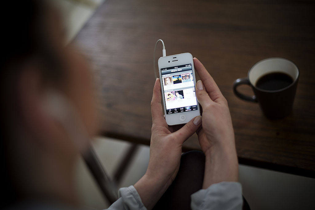 A woman listens to music on her phone