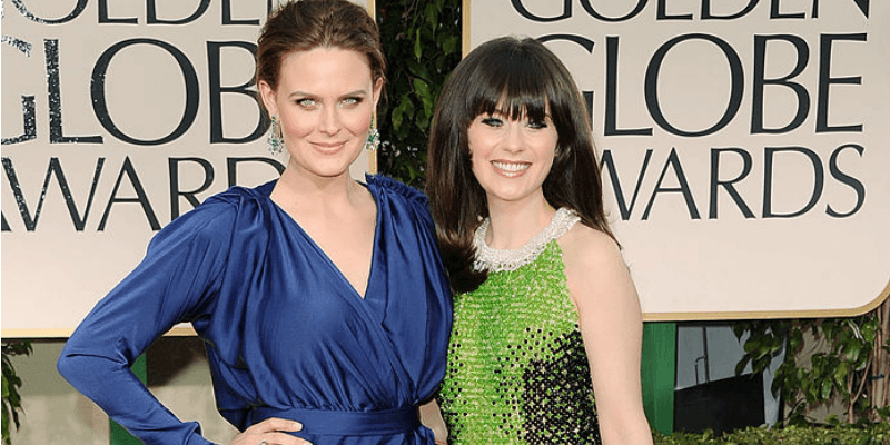 Zooey Deschanel and Emily Deschanel pose together on the red carpet.