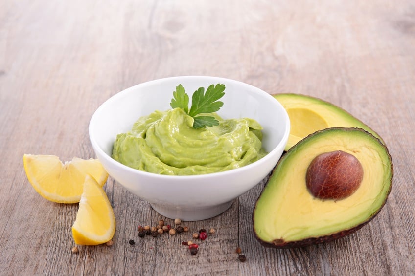 avocado and guacamole on wooden background