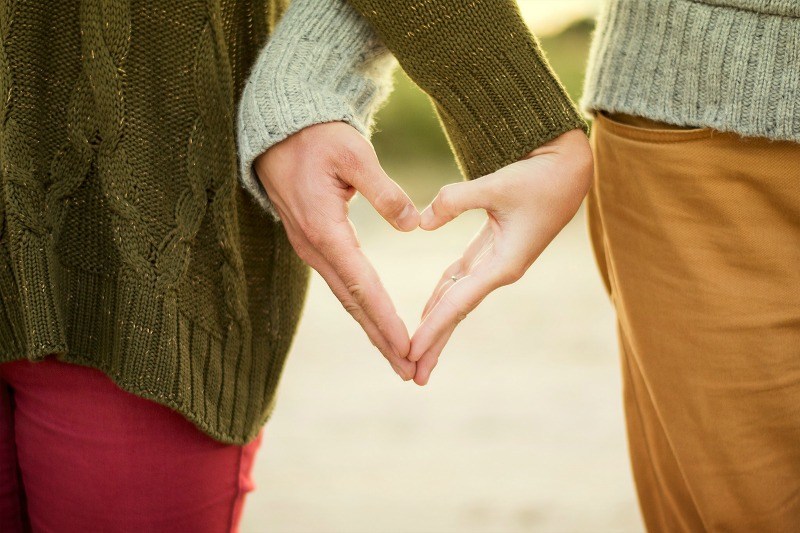 a couple making heart shaped hands