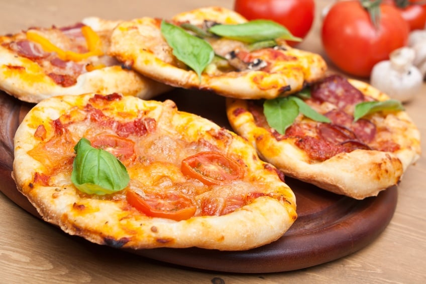 small pizzas and engredients on a table