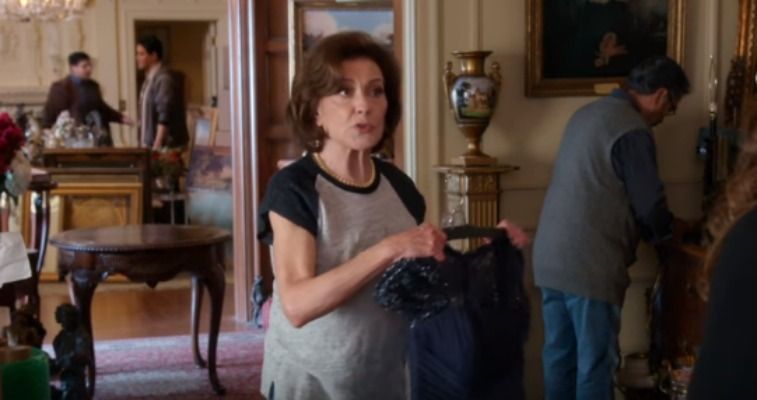 Woman in a t-shirt holding a dress in a nice house in Gilmore Girls: A Year in the Life