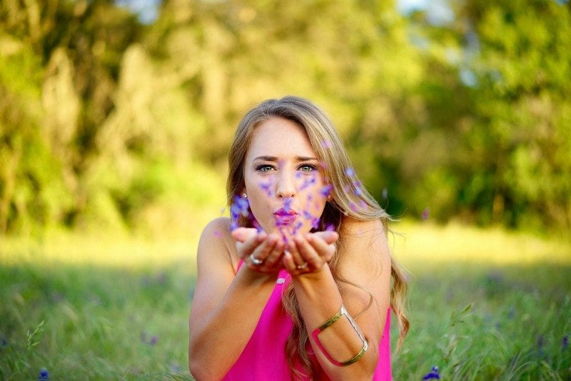 girl blowing flower petals