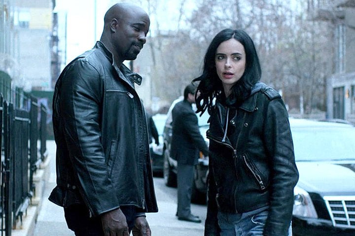 Luke Cage wearing a leather jacket, next to Jessica Jones in a similar jacket