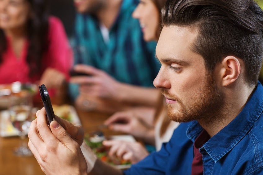 man with smartphone and friends