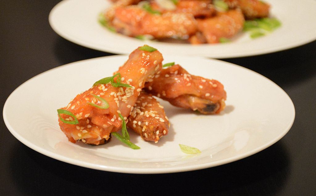 a small plate filled with orange-sesame chicken wings