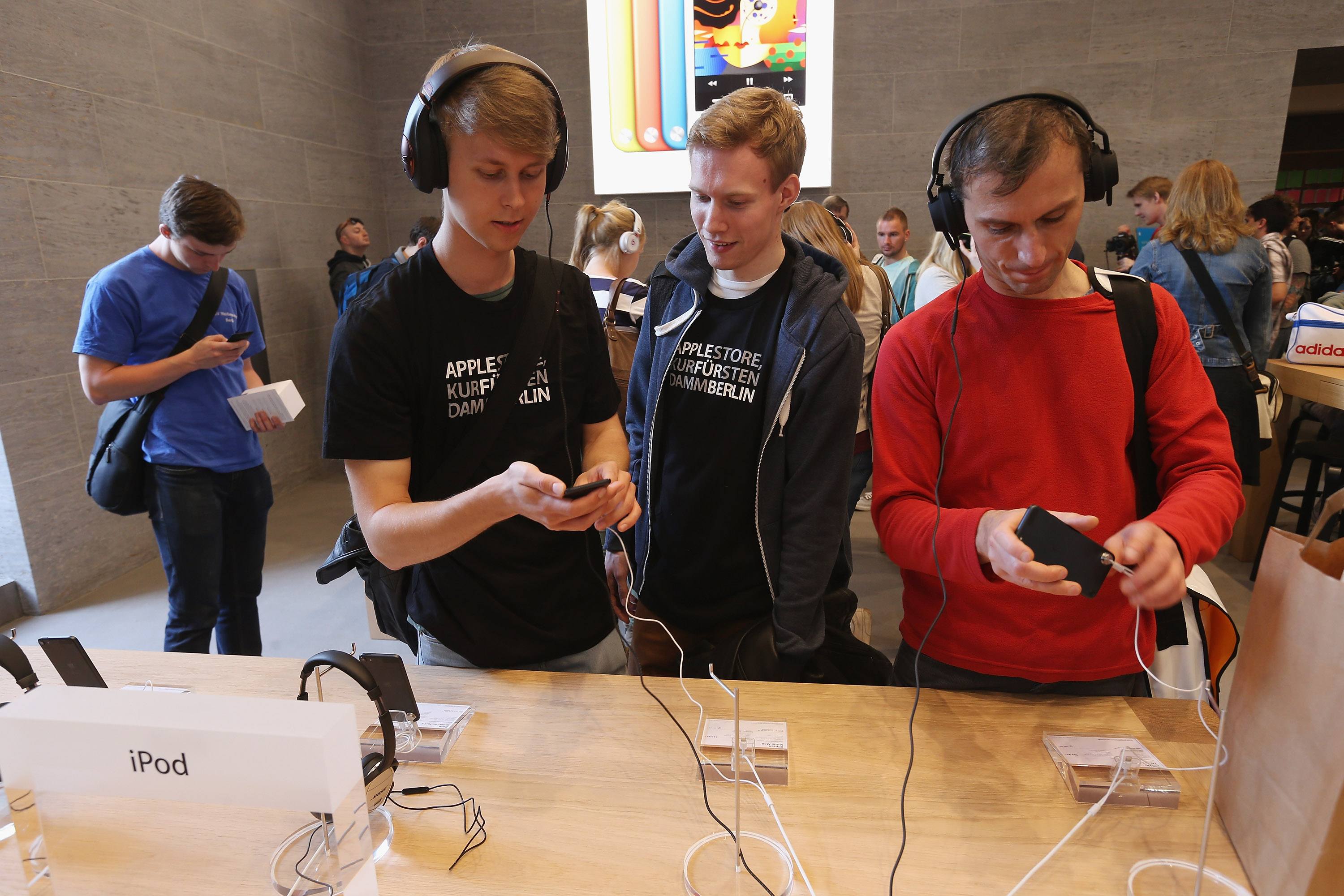 Visitors try out hifi headphones on Apple iPods at the new Apple Store