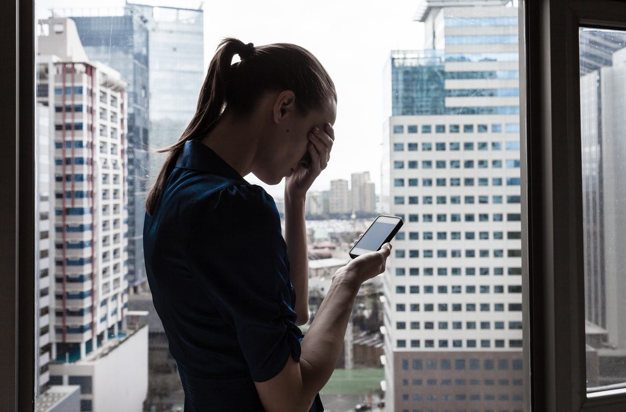 Stressed young businesswoman with her cellphone
