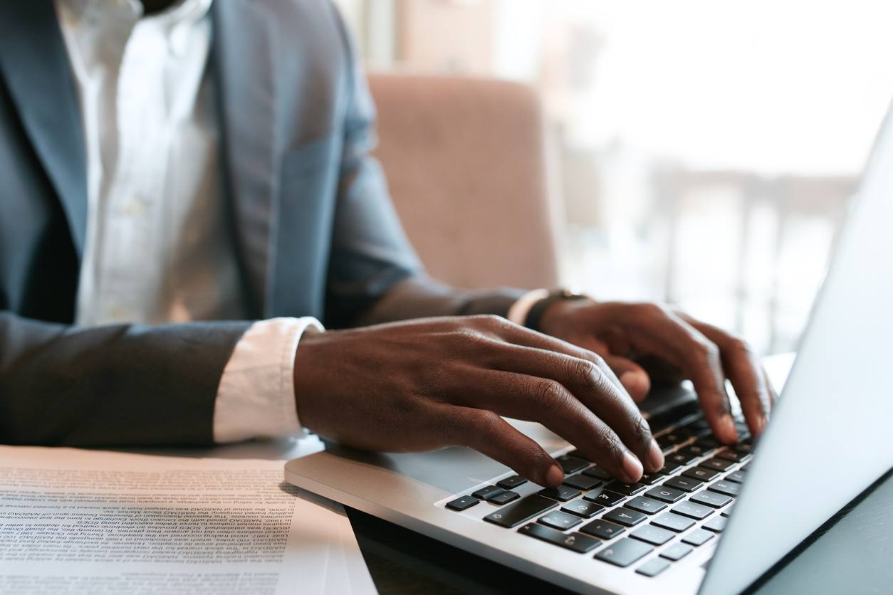 Businessman working on laptop with some documents on table