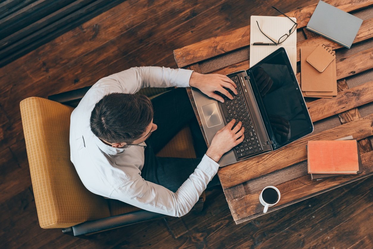 young man working on laptop while sitting at his working place