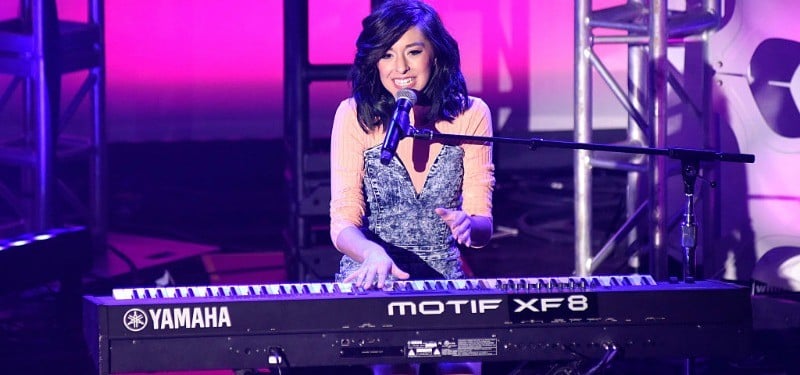 Christina Grimmie singing and playing on a keyboard. 