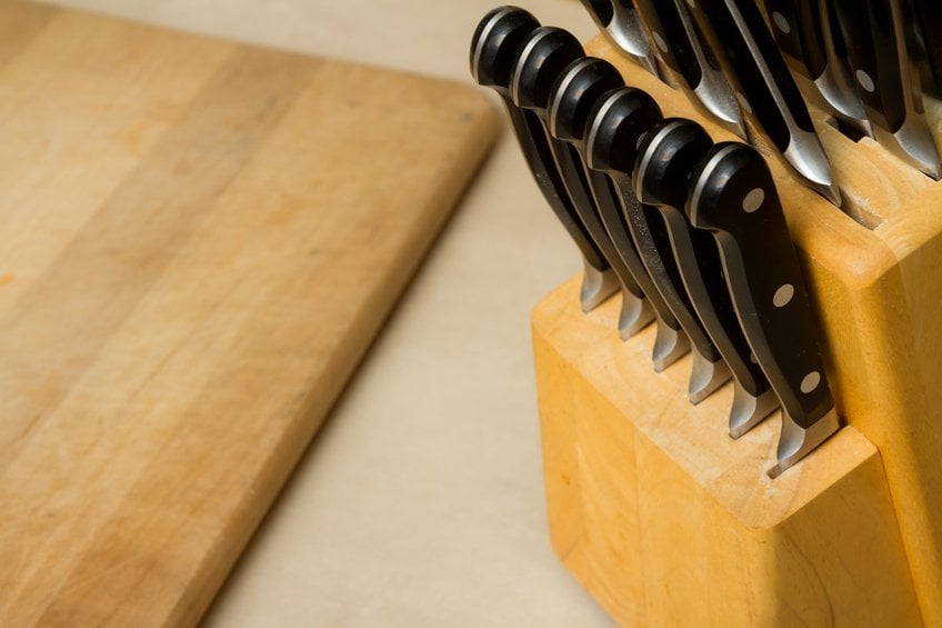 bunch of knives with a cutting board