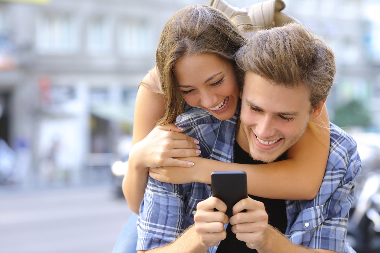 friends laughing funny and having fun with a smart phone