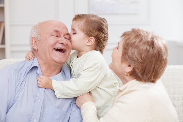 old man and woman spending time with their granddaughter