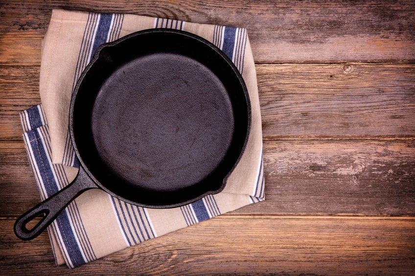 Empty cast iron skillet with tea towel