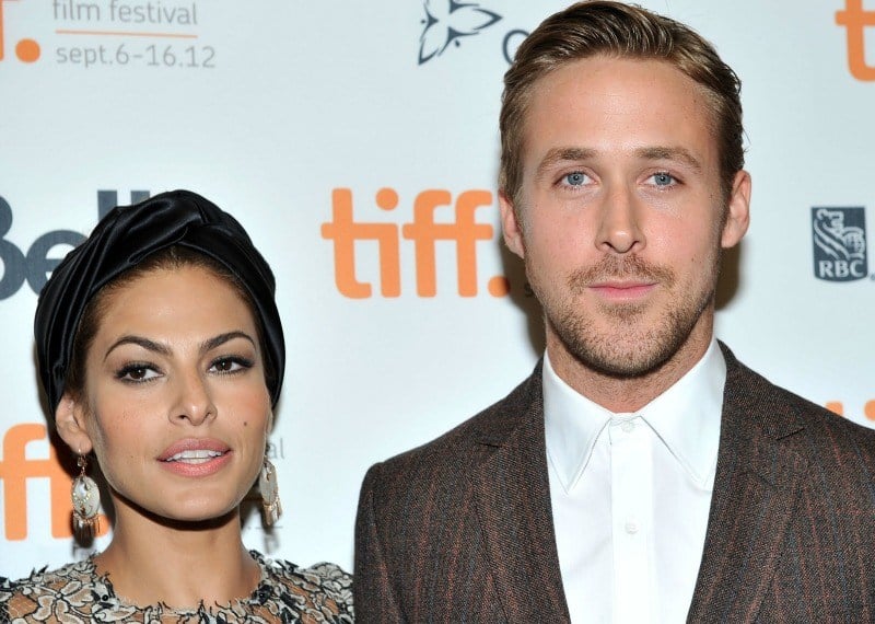 Ryan Gosling and Eva Mendes pose side-by-side on a red carpet. 