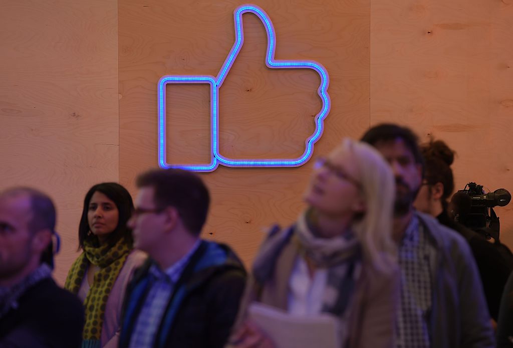 People are seen in front of an light installation during a press preview of the "Facebook Innovation Hub"