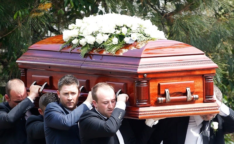 Pallbearers carry the coffin of an Australian cricket legend during a funeral