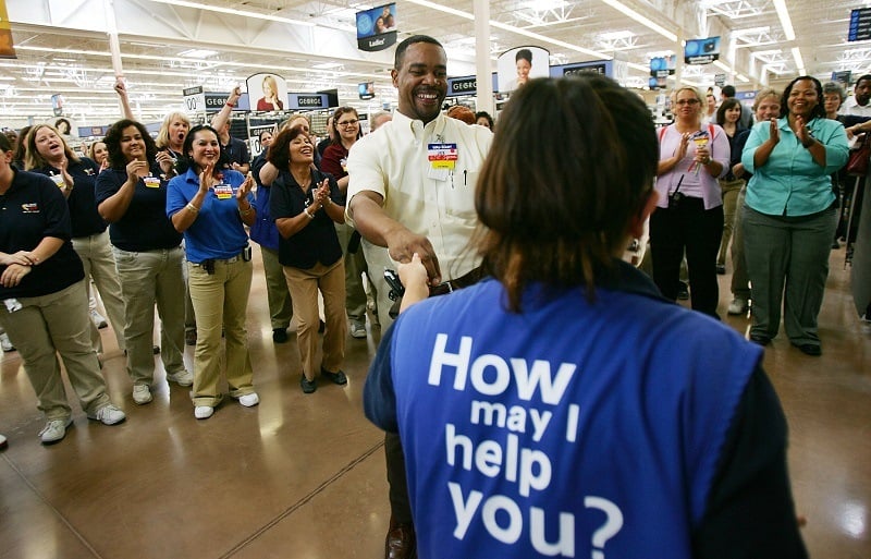 A Walmart associate receives a promotion in front of cheering coworkers, advancing her career path