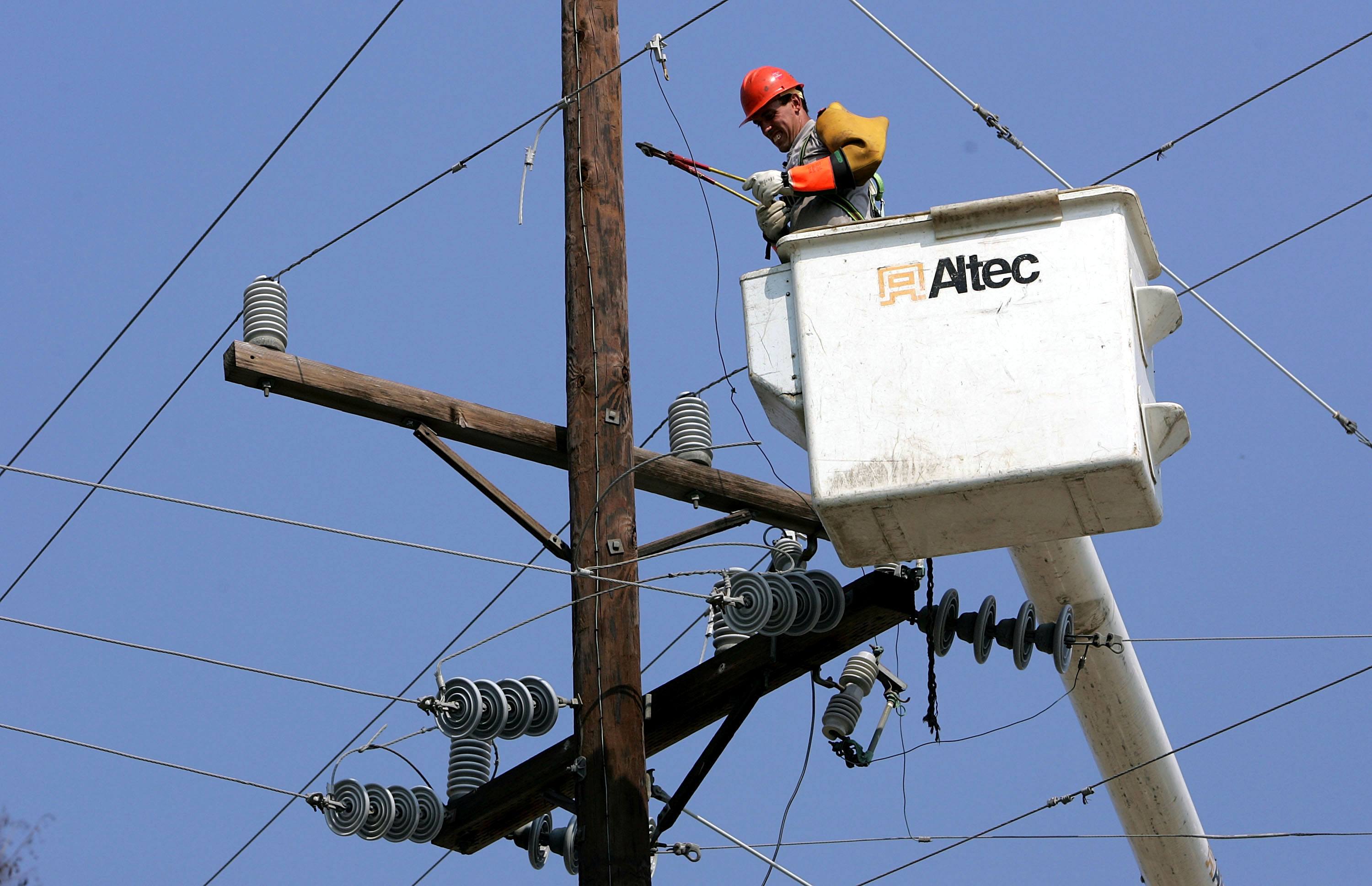 A utility worker repairs a power line