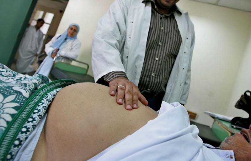 A doctor examines a patient suffering from liver damage A doctor examines a patient suffering from liver damage