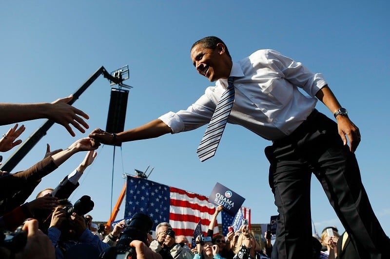 Barack Obama shakes hands with people during a campaign rally