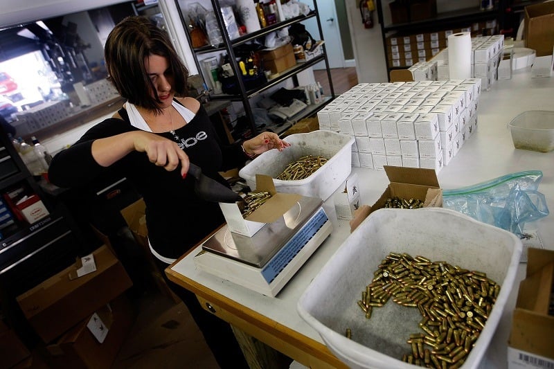 A worker weighs a box of 5.56mm cartridges as she packages them for shipping