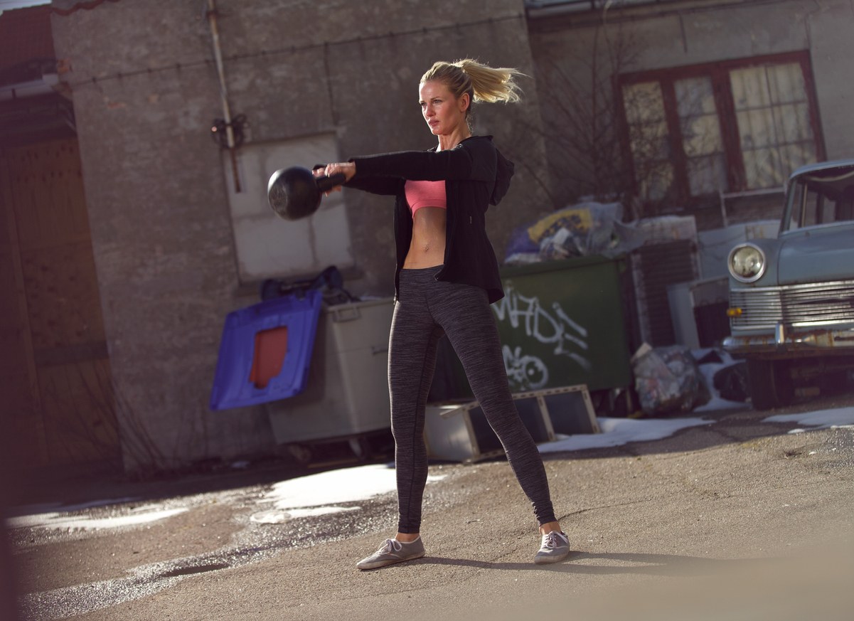 woman swinging the kettlebell during gym training
