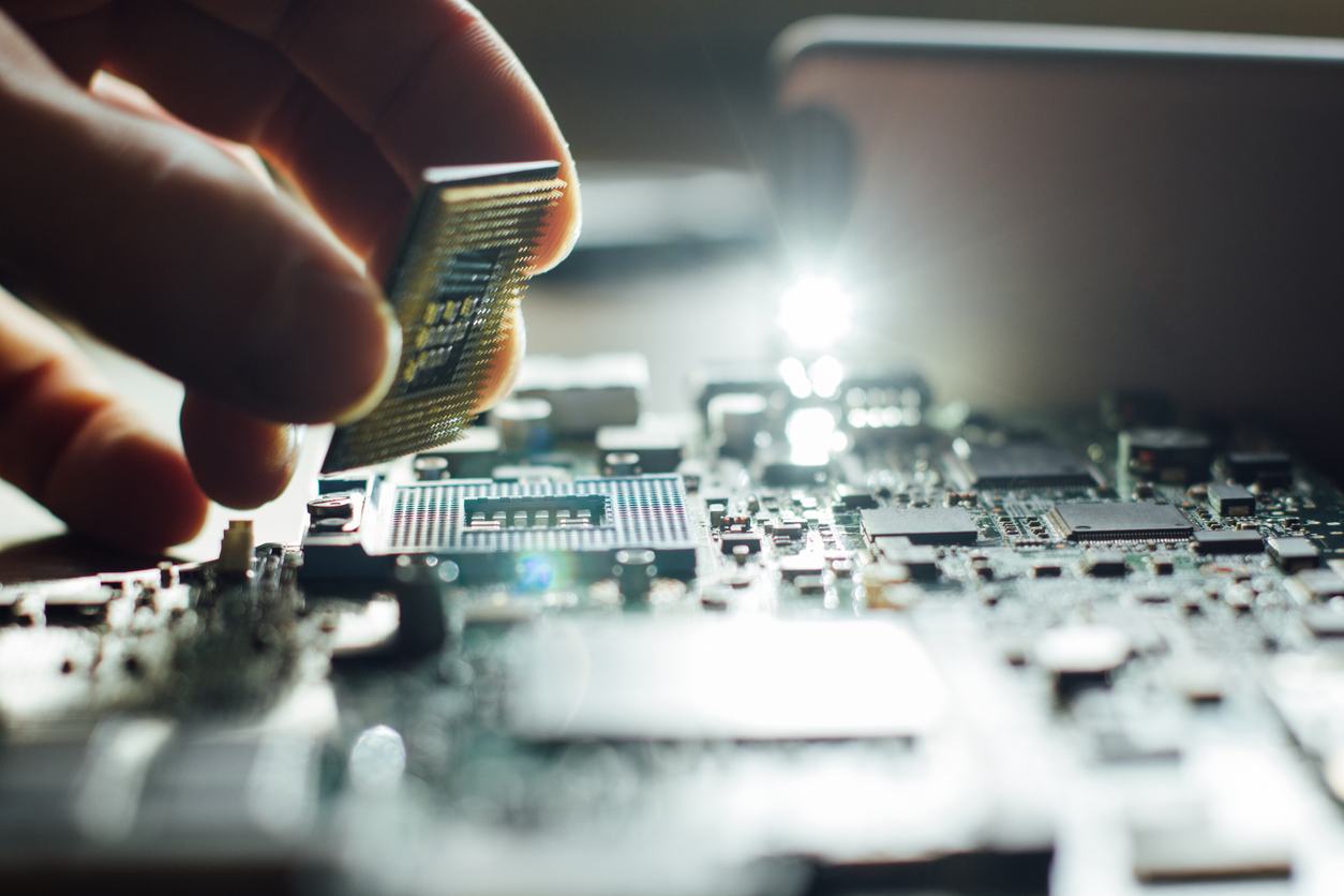 Technician plug in CPU microprocessor to motherboard socket