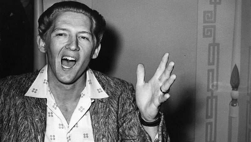 Jerry Lee Lewis talking and using his hands in a black and white photo