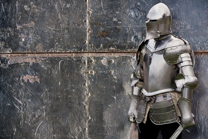 Knight in silver armored suit against the wall