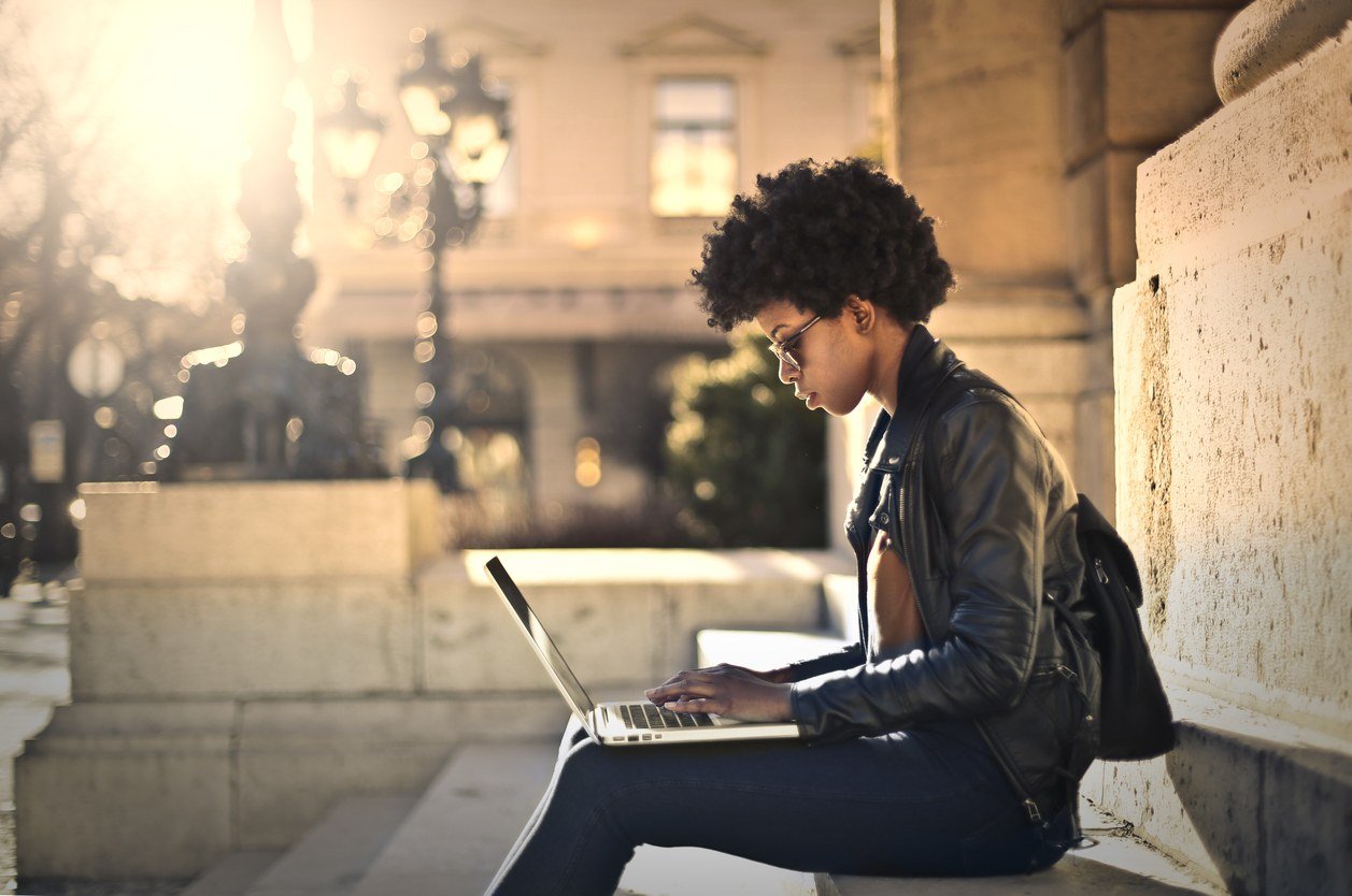 Woman working on laptop outside the building