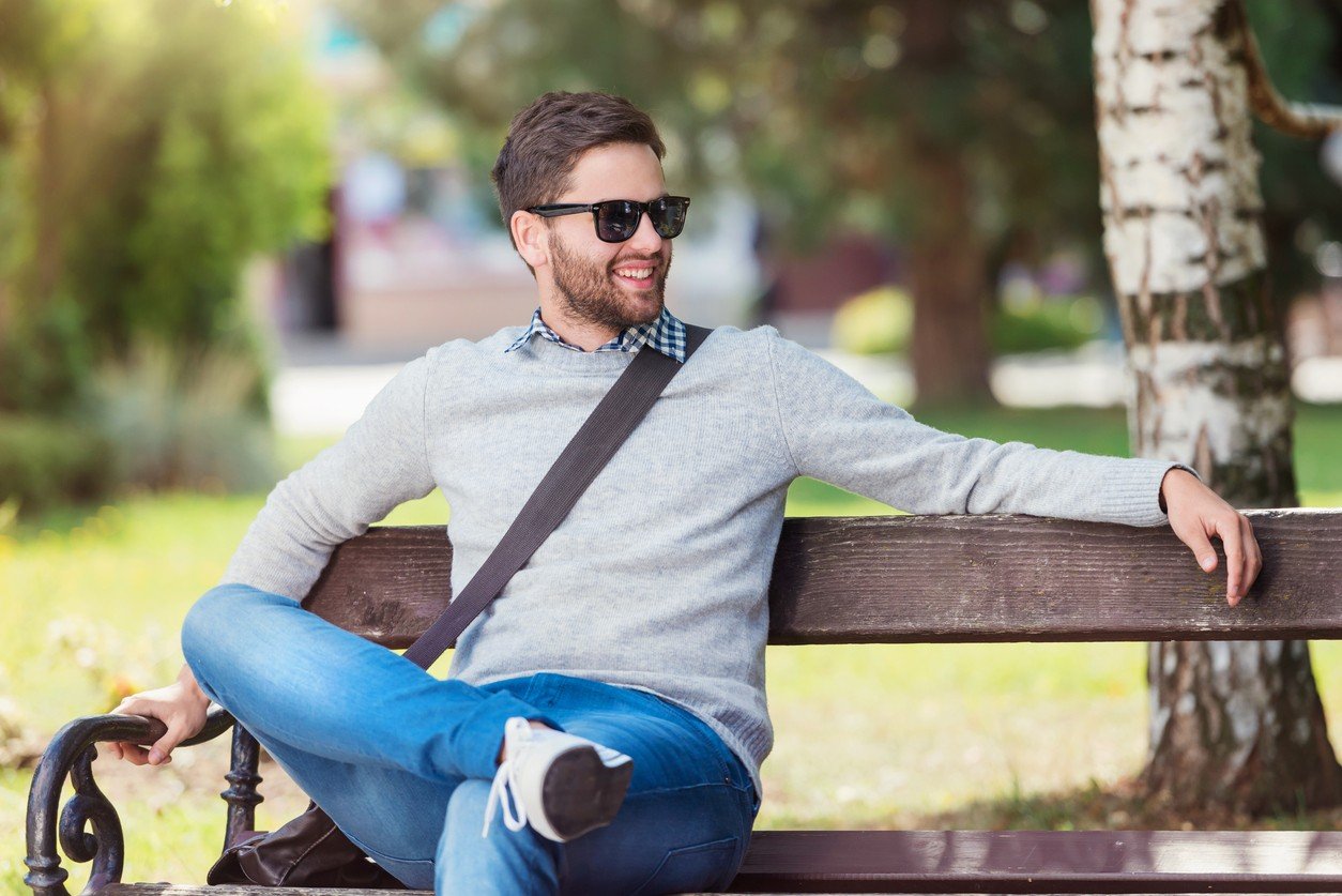 young man sitting on park bench