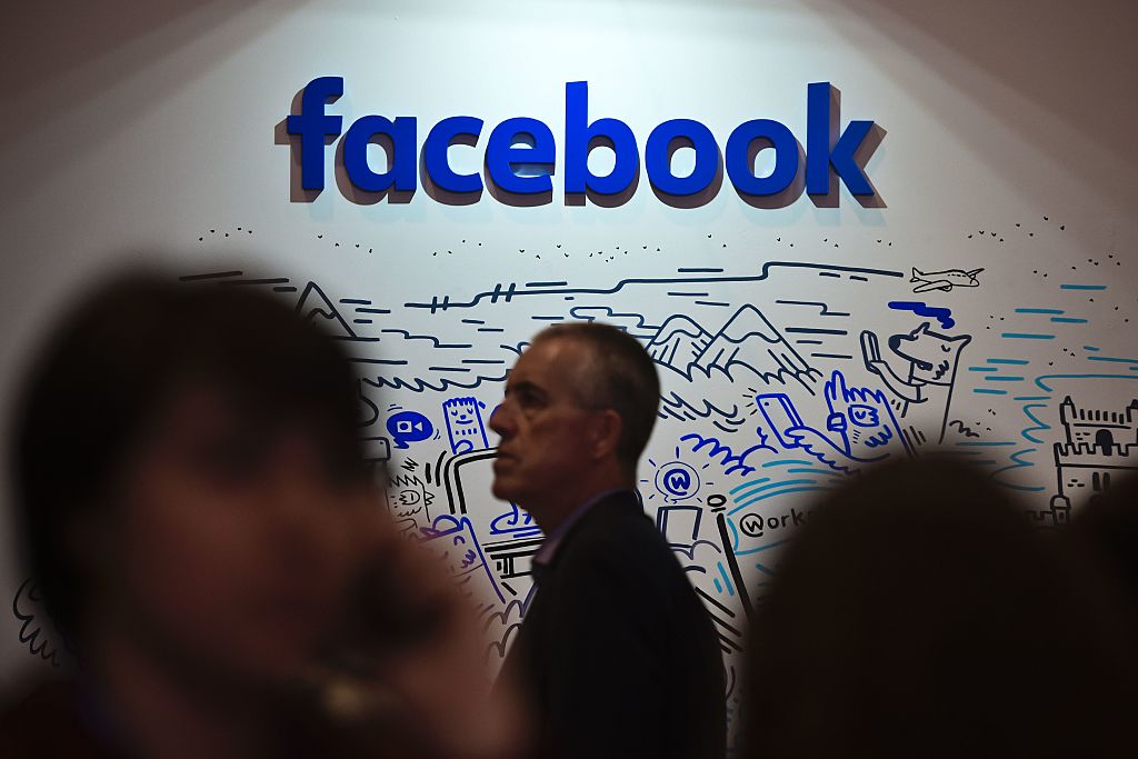 People pass by an artwork by artist Geo Law at Facebook's space during the Web Summit at Parque das Nacoes, in Lisbon on November 9, 2016.