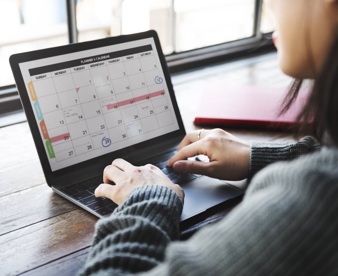 Woman using planner on laptop