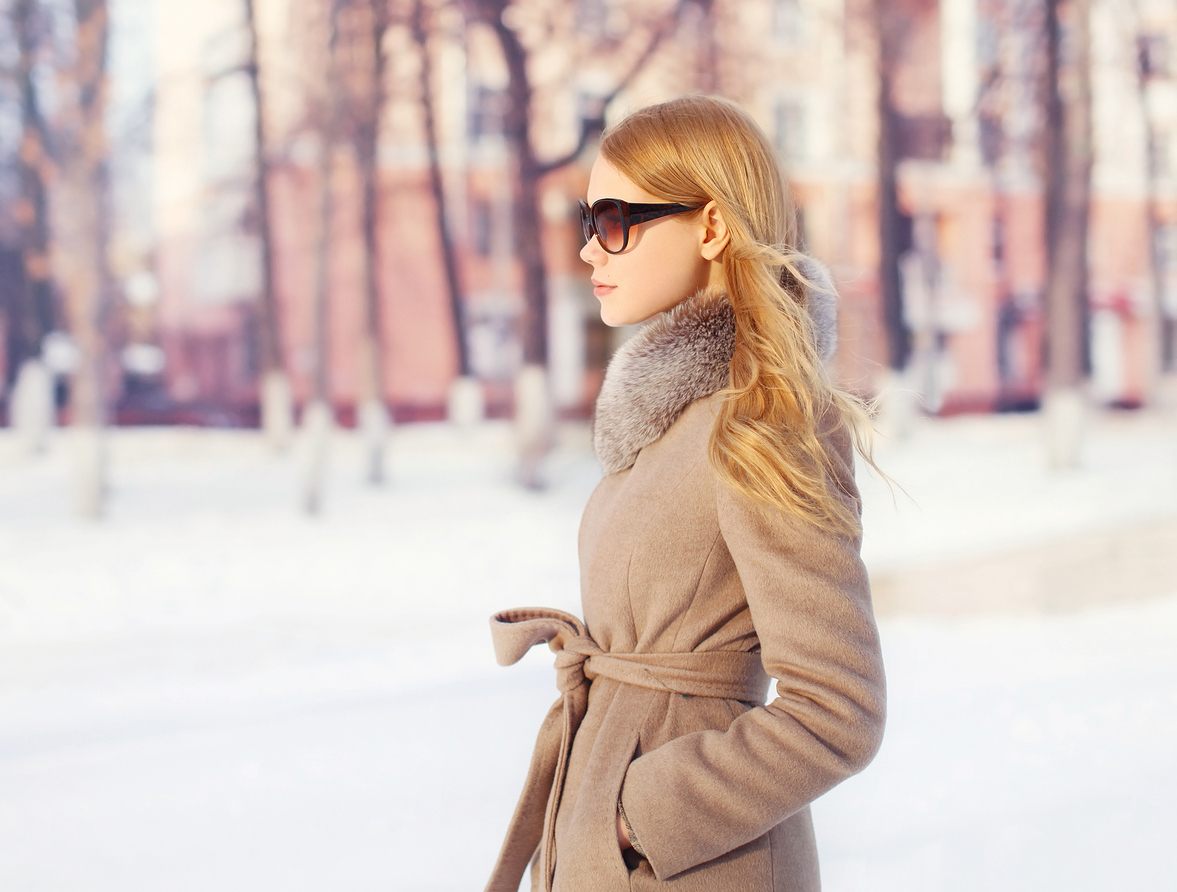 beautiful elegant woman wearing a coat jacket and sunglasses in city